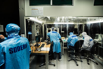Ingénieurs préparent et assemblent des éléments du sismomètre ultrasensible SEIS Seismic Experiment for Interior Structures, dans une hotte à flux laminaire d'une salle blanche de l'entreprise Sodern.