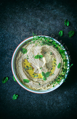 Hummus with fresh herbs and olive oil.