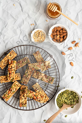 Honey nut bars on a wire rack with ingredients in bowls.
