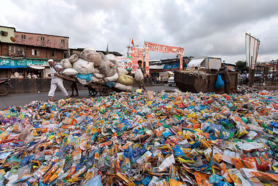 A pile of wrappers from plastic bottles sits next to a dumpster in the Dharavi slum, Mumbai, India.