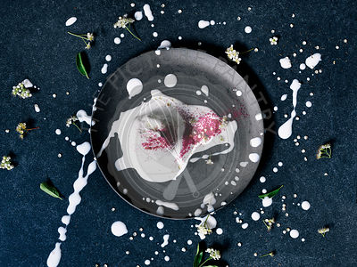 Vanilla ice cream, melting on a black plate