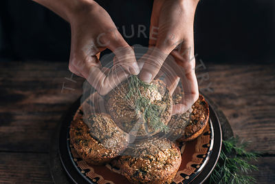 Persons Hands wth Corn muffins bread with leaf of chard