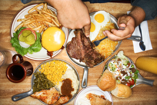 Man eating from multiple plates of food