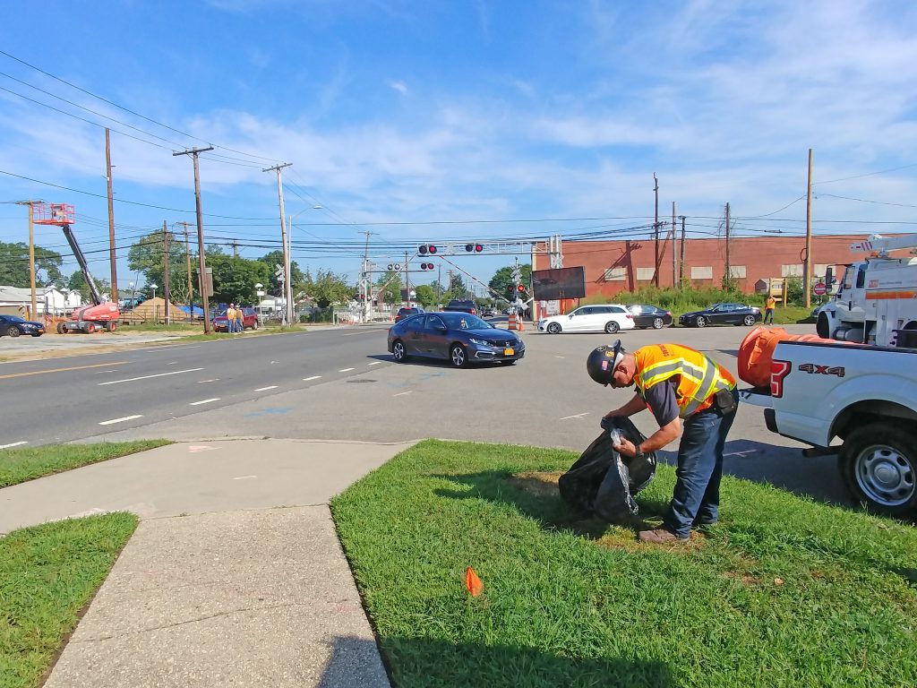3TC’s Dennis Feeney addresses community litter concerns at the site of the New Hyde Park Road grade crossing elimination project in August.