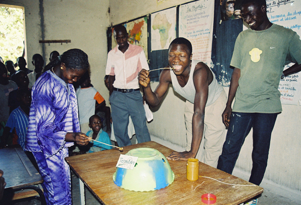 Dondo-Kante (far right) PEN's-December Educator of the Month at one of Amy Clanin's chimpanzee workshops in Senegal, teaching students how to 'fish-for-termites' using peanut butter and raisins. Photo by: Amy Clanin.