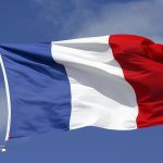 french flag waving against blue sky