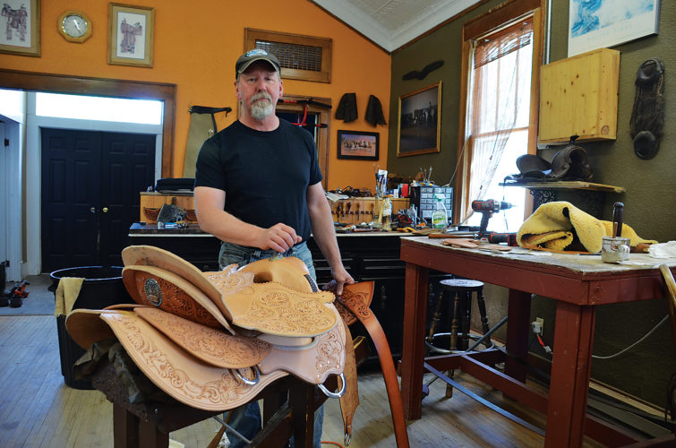 Eloise Ogden/MDN
Shawn Kramer, in his Sandhills Saddlery shop, is shown with the one-of-a-kind saddle he was commissioned to make for District 5 trustees of the North Dakota Cowboy Hall of Fame.