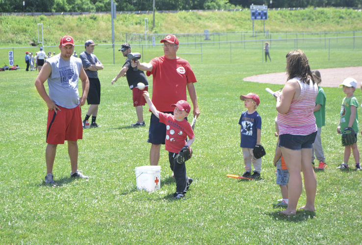 Reds Legends clinic director Mike Wagner tests the pitching speed of youngsters during a drill Tuesday at Jackson Park in Vienna. Photo by Jordan Holland.