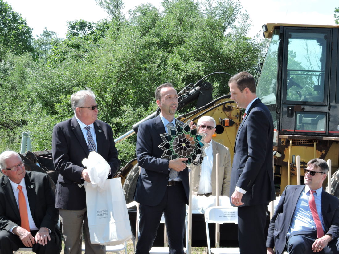 Kris Hopkins, right, executive director of the West Virginia Development Office, presents a gift of West Virginia-made glass art to Dave Watkins, left, president of Pietro Fiorentini USA, and Sergio Trevisan, vice president, during Friday's groundbreaking ceremony in the Three Springs Business Park. -- Craig Howell