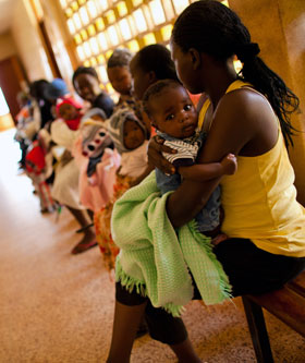 Mothers wait in line to receive vaccines for their children