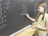 child doing math on blackboard