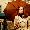 Moira MacTaggart, pensive in a trench & umbrella