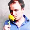 Actor Rory Kinnear sniffing a yellow flower