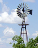 Windmill, trees around base, white clouds behind