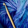 wooden crochet hook on deep blue yarn