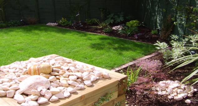 Cubes were constructed from new oak railway sleepers to house, on one side, a cobble water feature to give sound and movement - this could be viewed from the dining room, and on the other, a planting bed for alpines. 