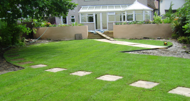 The drainage problem was dealt with by the construction of a soakaway so that the new lawn could be laid. This was designed with a curving path leading the eye across the garden to a drilled boulder water feature from which bubbles over cobbles to one side.