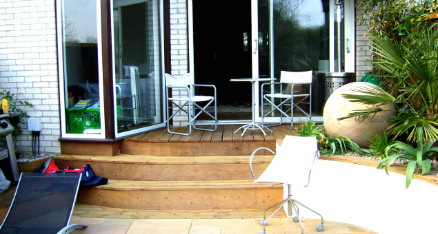 Decking steps were used to link the house to a natural sandstone patio with an attractive nautical star insert. Our clients now had a much larger dining area which was far more practical to use.