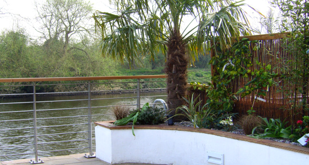 The dining area was surrounded by rendered raised beds with exotic planting in bright colours against a backdrop of natural willow screens.
