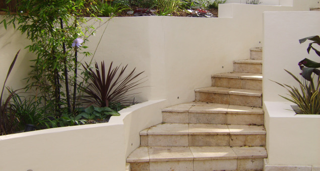 Curved steps lead to a small lawn and summerhouse. The addition of a custom-built play structure, make this an area for the children and adults alike to enjoy. The result is a multi-functional outside space with a definite ‘wow’ factor. 