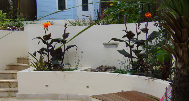 Raised beds filled with semi-tropical planting enhance the sense of drama with architectural foliage and vibrant colours. 