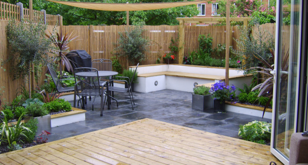 The new decked area leads out from the house, stepping down to a colour contrasting slate paved patio area with room for a table and chairs. Our clients’ favourite jewel colours bring life to the scheme, with deep blue Agapanthus, rich pink Day Lilies and beautiful purple Clematis among the flowering plants.