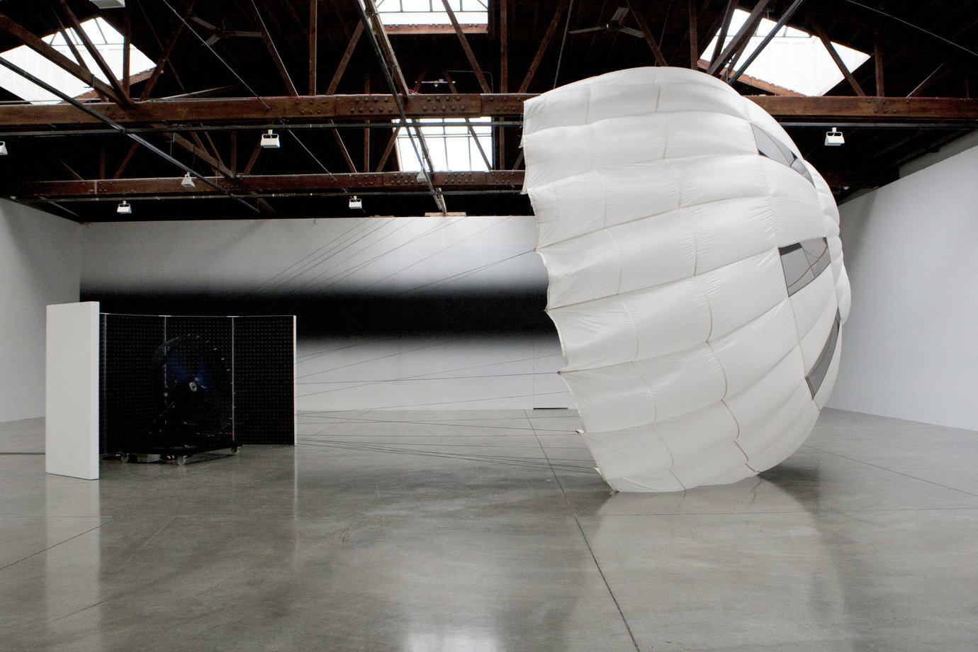 , 2011. Parachute, wind machine, sound proof paneling, installation dimensions variable, site specific.
