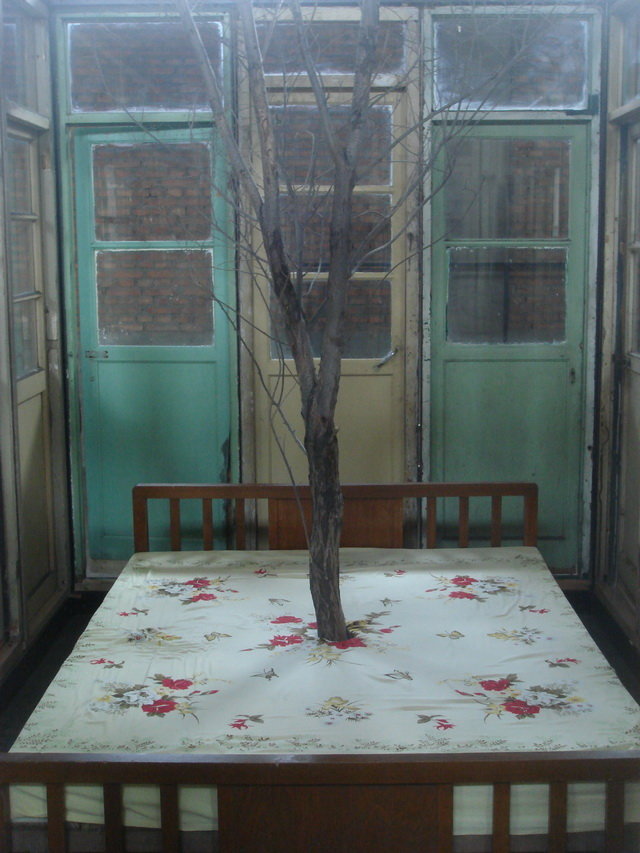 . Steel pipe, wooden door, wooden bed, withered tree, bed sheets, 392 x 245 x 265 cm; bed size: 150 x 200 x50cm; tree height: 500cm .