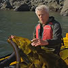 a man in a kayak holding kelp