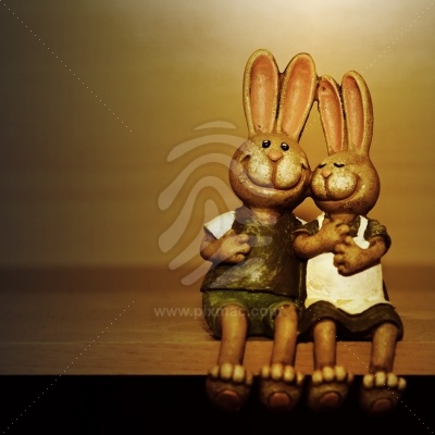 Zwei glückliche lächelnde Osterhasen sitzen auf Tisch