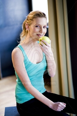 Young Woman Eating Green Appleфотография
