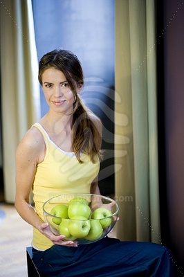 Young Woman Holding Bowl with Green Apples picture