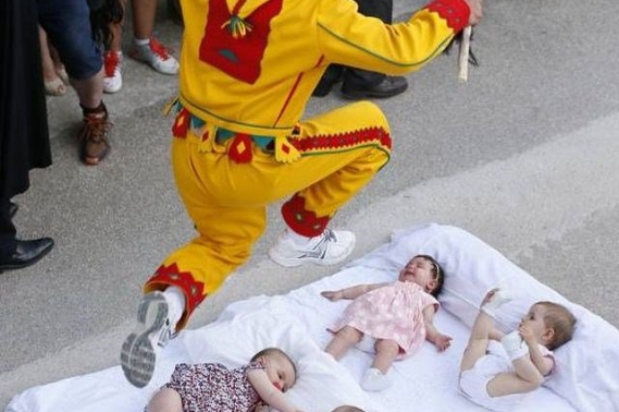 Imagem de capa - Homens se vestem de “diabo” e saltam sobre bebês para purificá-los