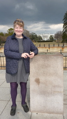 Caption: Carolyn Crouch leaning on the Zero Milestone. But, 'What is the Zero Milestone?' you ask... Take a listen!