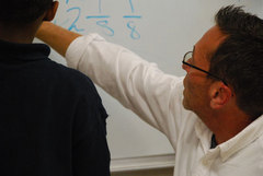 Caption: Teacher Joe Curtis working with a student at Hardy Elementary School in Chattanooga, Tennessee, Credit: Emily Hanford