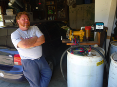 Caption: Ken Kirkland in his garage, where he produces homemade biodiesel from restaurant-used vegetable oil., Credit: Photo by Roisin Hunt