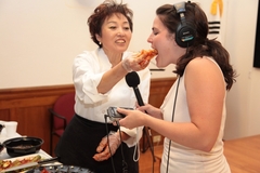 Caption: Chef Young Lee offers Reporter Emily Friedman a taste of cabbage kimchi., Credit: Korean Cultural Center