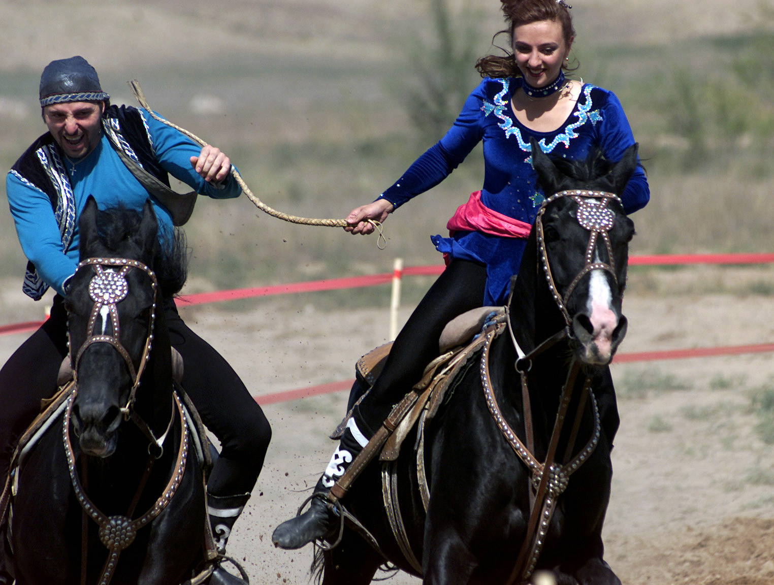 Caption: Kazakhstani youth in engage in the traditional courtship game of Kyz Kuu. , Credit: WikiCommons. 