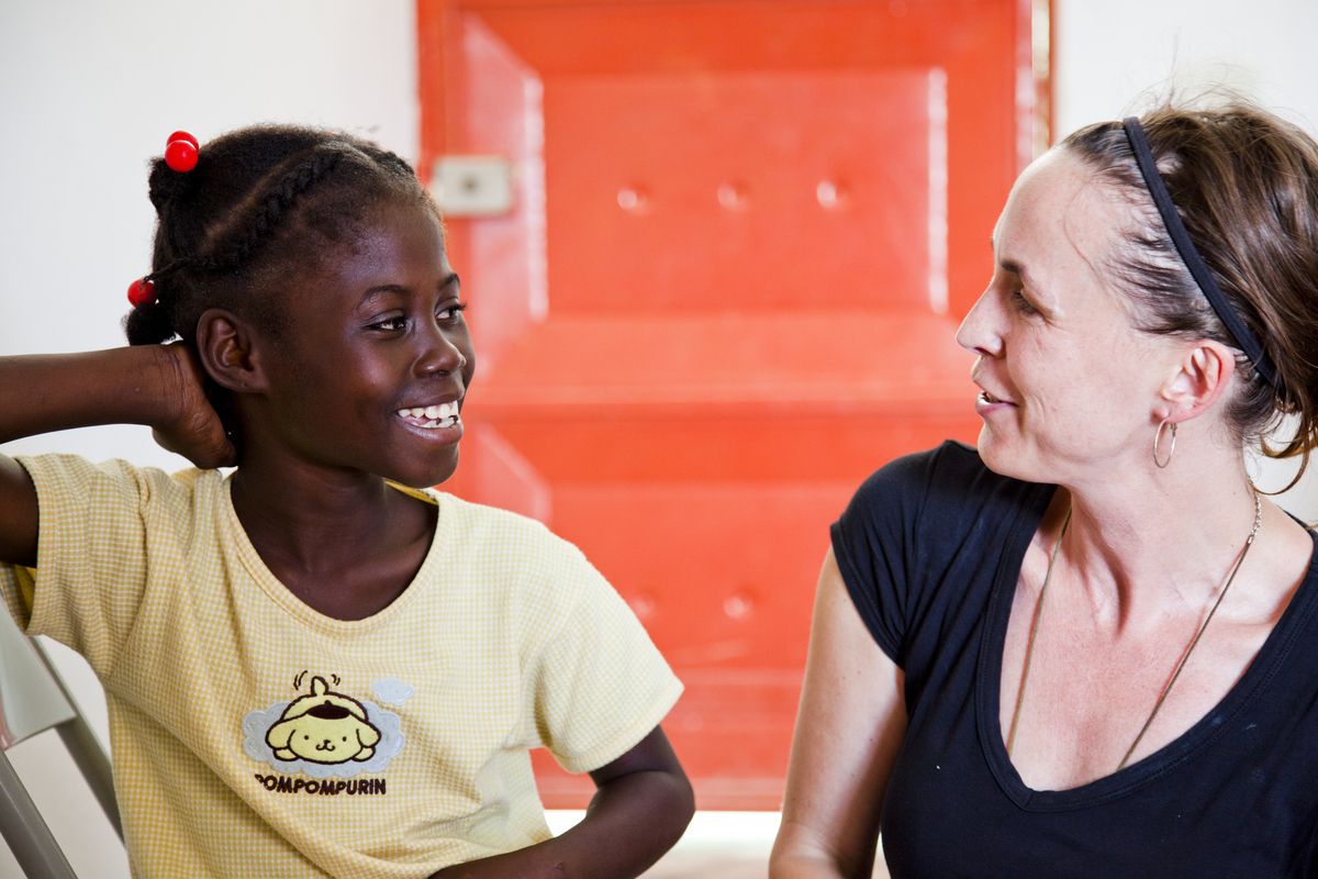 Caption: Martha Adams, producer of the film '10x10', with nine-year-old Marie-Angeline at the Center for Actions and Development in Haiti., Credit: 10x10/2011