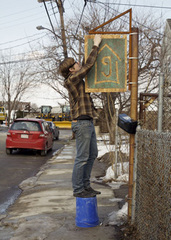 Caption: Marty Walsh hangs his sign at Geekhouse Bicycles., Credit: Jonathan Simmons