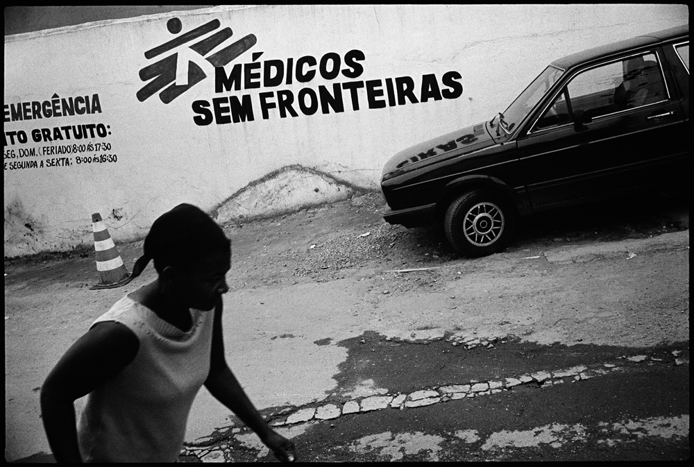 Caption: A woman walks past the entrance to the Doctors Without Borders clinic in Complexo do Alemao, Rio de Janeiro, Credit: Roberto (Bear) Guerra