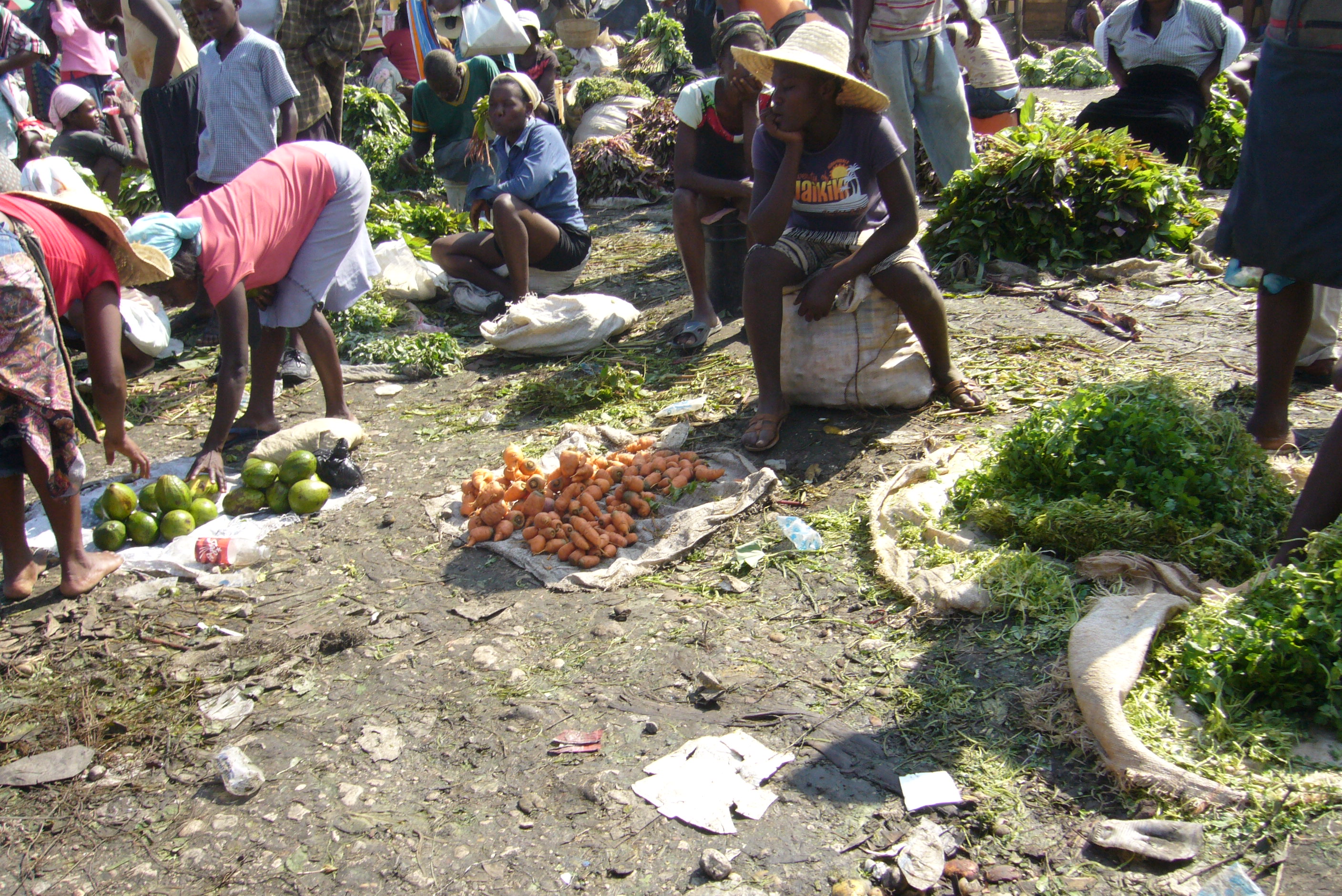 Caption: Women sell produce and used clothes at a street market in Lenbe, Haiti., Credit: Ruxandra Guidi