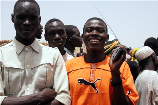Caption: Refugees in Darfur listen to a radio program., Credit: Photo courtesy of the Associated Press.