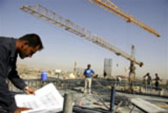 Caption: Cranes tower over a construction site in Irbil., Credit: Associated Press