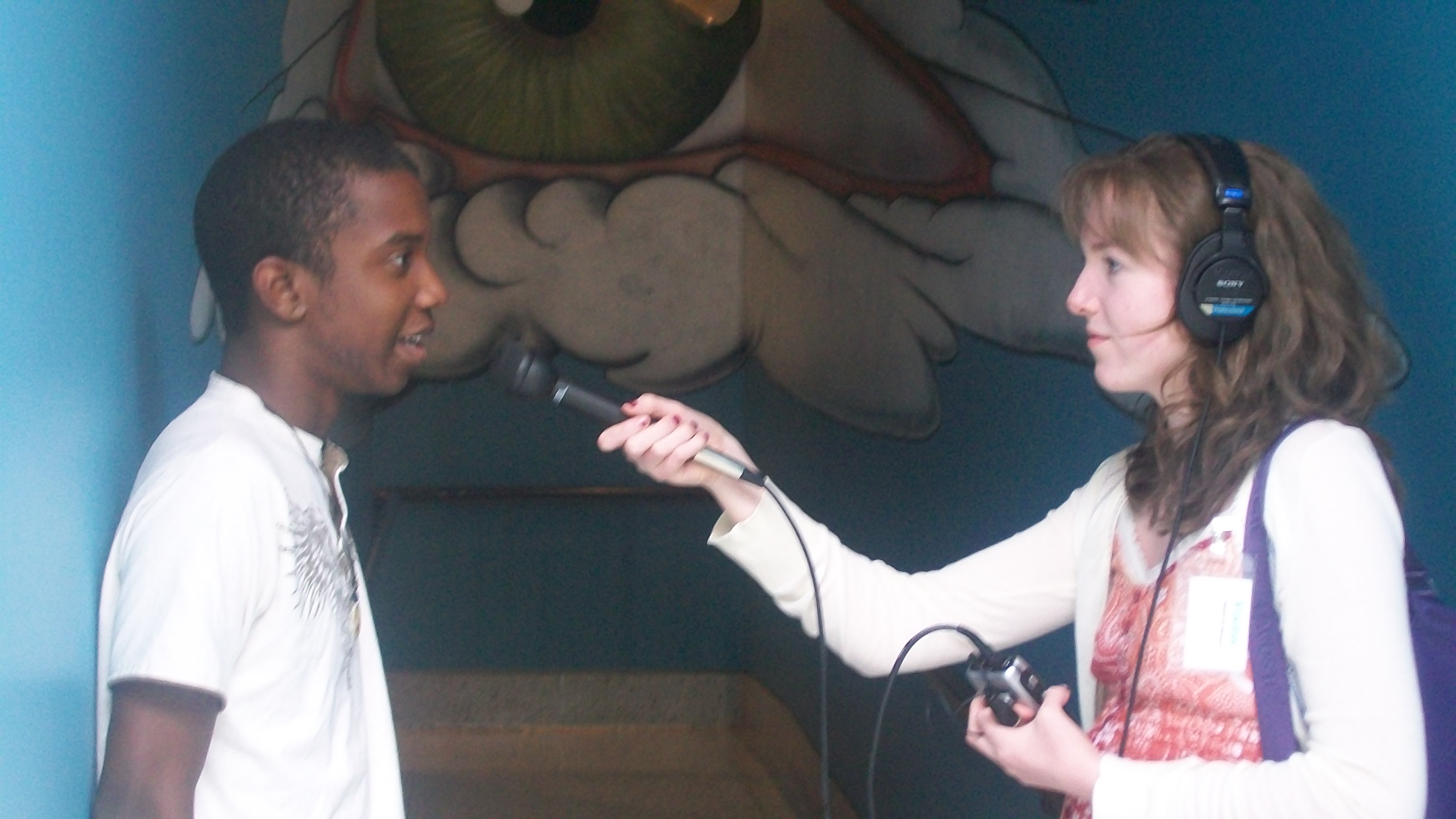 Caption: Lizzie Kirschner interviews Jamil, an intern at the Seattle Art Museum about his work for the Design Your 'hood project, Credit: Nate Hearth