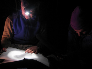 Caption: John Casteen reads a poem by the light of his headlamp., Credit: Greg Antrim Kelly