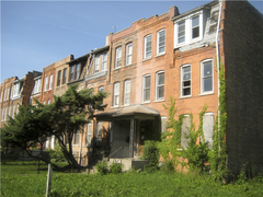 Caption:  Historic rail worker rowhouses in Chicago's Pullman neighborhood. The one on the right is boarded up and in foreclosure., Credit: WBEZ/Ashley Gross