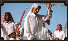 Caption: Qatari men perform a traditional Ardha (warriors' dance)