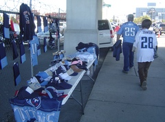 Caption: Two Titans fans walk by a vendor table in Nashville on the way to LP Field., Credit: Blake Farmer