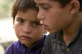 Caption: Two Afghan boys sit together in their village that was suffering from a shortage of food and water, Monday July 29, 2002 in Qiqay, 32 kilometers (20 miles) southeast of Khost, Afghanistan., Credit: Associated Press